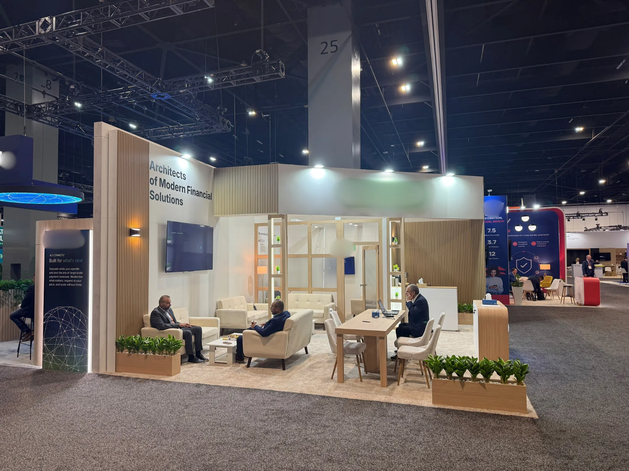 Light wood slat and white exhibition stand with lounge seating and meeting table at SIBOS 2026, Miami